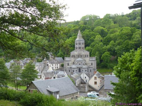 Durch das frische Grün des Hügels wirkt das Grau des Dorfes fast freundlich