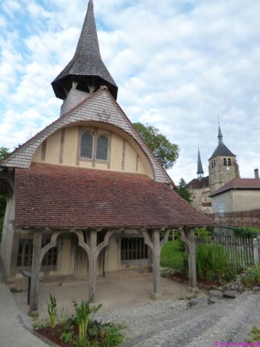 Die alte Holzkapelle und dahinter die große Kirche aus Stein