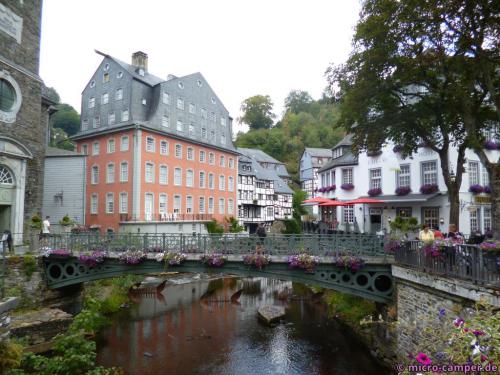 Das Rote Haus in Monschau an der Rur, am Ende der Brücke die ev. Stadtkirche