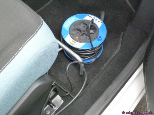 Kabeltrommel im Beifahrerfußraum, eingesteckt das Kabel vom Ladegerät