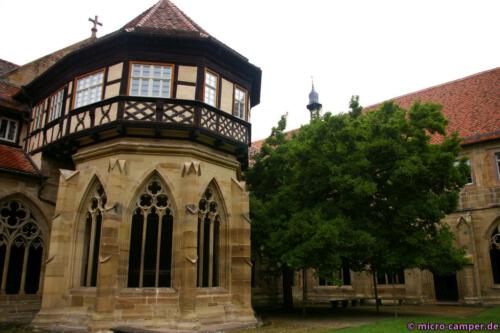 Das Brunnenhaus von außen, daneben eine große Magnolie