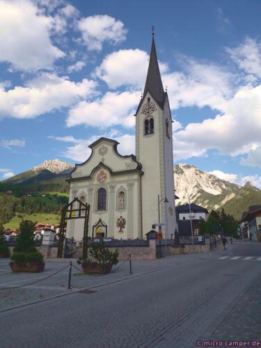 St. Vigils Kirche ist umrahmt von Dolomitgipfeln